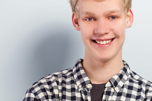 Portrait of young handsome guy over grey background