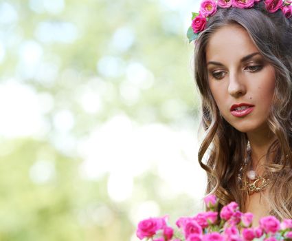 Portrait of a beautiful girl holding bouquet of flowers in the park