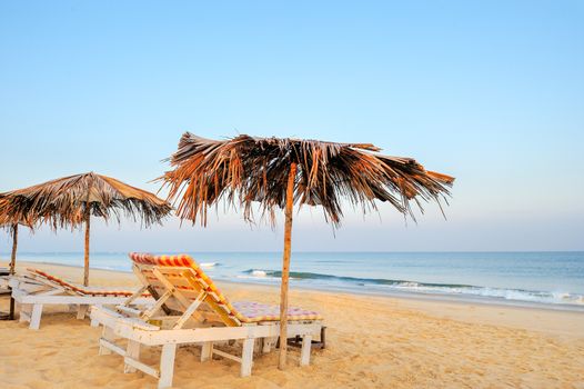 Beach umbrellas and deckchair on the tropical beach in Goa, india