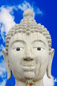 The Head of Buddha Image and Cloudy Blue Sky Background.