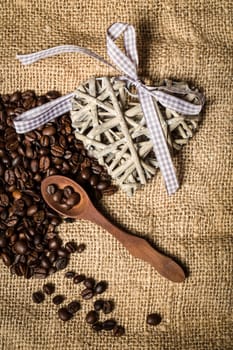 pile of fresh and bio aromatic coffee beans and wooden spoon with space for text