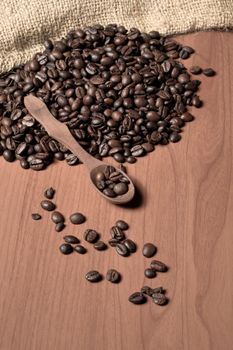 pile of fresh and bio aromatic coffee beans and wooden spoon with space for text