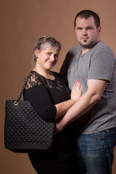 Studio shoot of beautiful fashion xxl woman with her husband, happy couple love concept