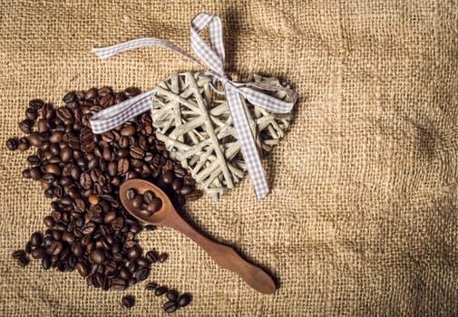 pile of fresh and bio aromatic coffee beans and wooden spoon with space for text