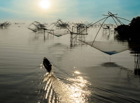 The Fisherman Boat and Square Fish Net in Morning Sunrise at Songkla Lake Thailand.
