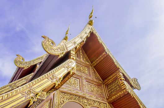 The Buddhist Temple Art with Naga Structure on Gable and Blue Sky in Thailand.