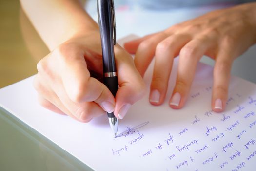 Writing a letter.girl writing a letter with a black pen