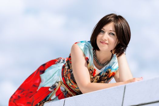 Brunette girl model in dress posing on exterior set