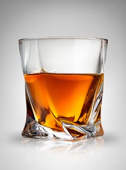 Glass of cognac on a gray background