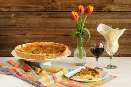 Cheese tart with red wine and red tulips on wooden background horizontal