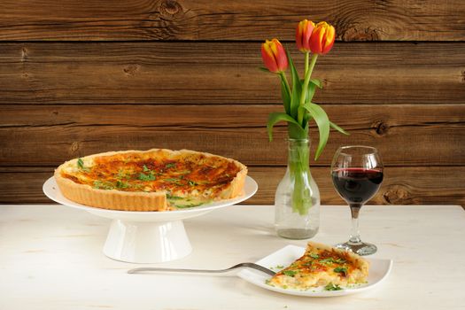 Cheese tart with red wine and red tulips on wooden background horizontal