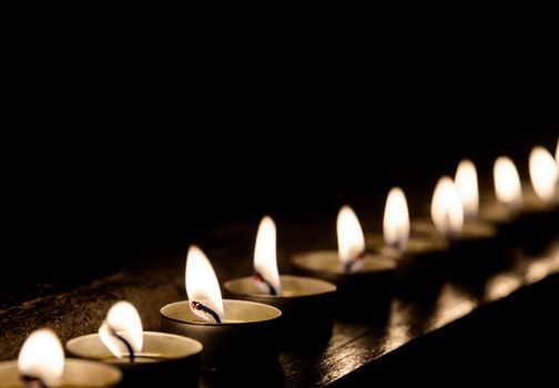 Lit candles in a row at night