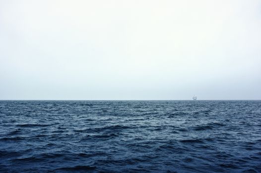 White ship far on the horizon over sea