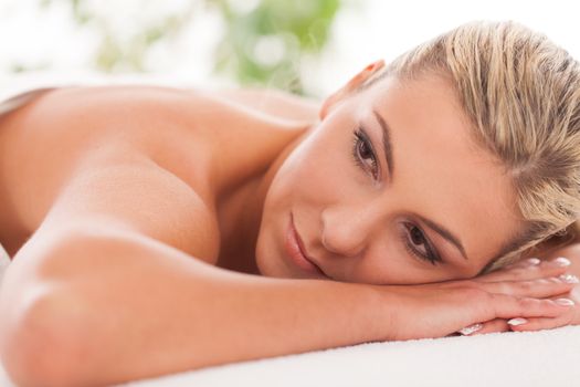 Beautiful caucasian woman with blond hair lying in a spa