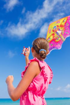 Back view of cute girl kite flying outdoor coast ocean