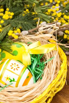 Easter eggs with bows in the basket over floral background