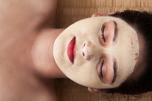 Beautiful indian woman with closed eyes and having face mask of calamine