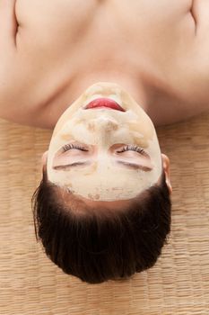 Beautiful indian woman with closed eyes and having face mask of calamine