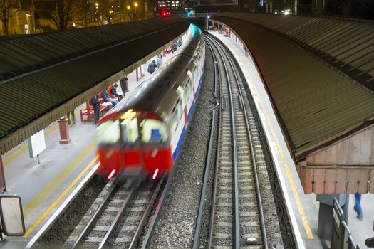LONDON, UK - FEBRUARY 04: High angle motion blurred shot of Underground train in Baron's Court station. February 04, 2015 in London.