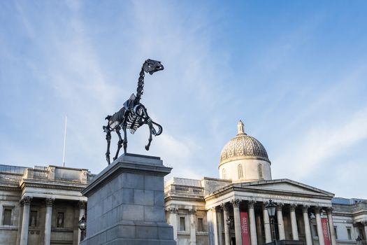 LONDON, UK - MARCH 06: Gift Horse sculpture by Hand Hacke, with National Gallery in the background, in Trafalgar Square. March 06, 2015 in London. The artwork shows live FTSE 100 tick in its ribbon.