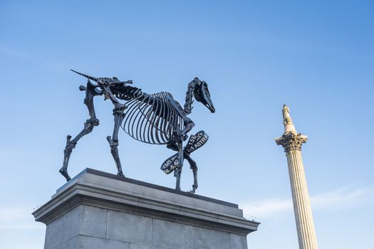 LONDON, UK - MARCH 06: Gift Horse sculpture by Hand Hacke, with Nelson's Column in the background, in Trafalgar Square. March 06, 2015 in London. The artwork shows live FTSE 100 tick in its ribbon.
