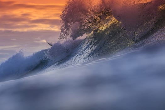 Colored Ocean Wave Falling Down at Sunset Time.