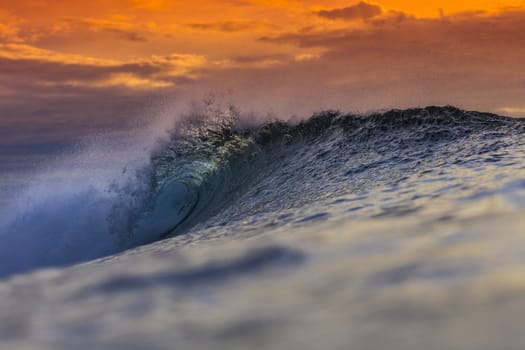 Colored Ocean Wave Falling Down at Sunset Time.