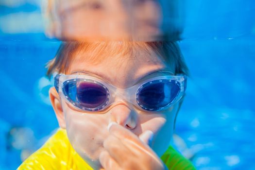 Underwater happy little boy in swimming pool