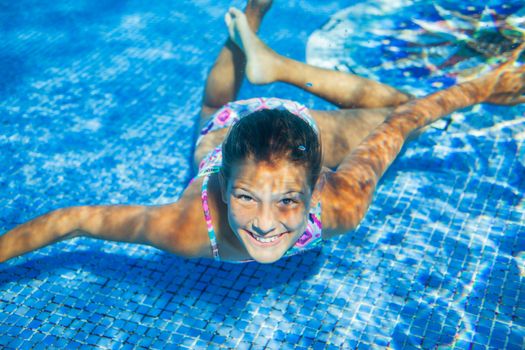 Underwater happy cute girl in swimming pool