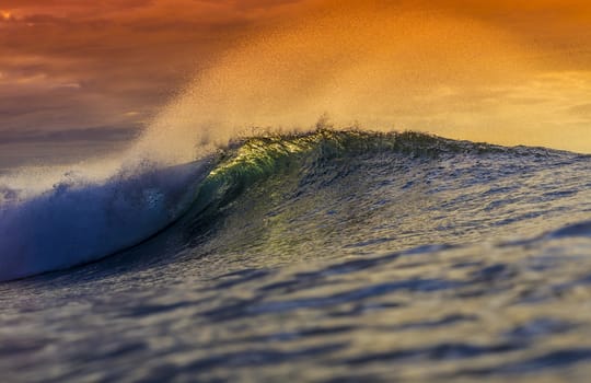 Colored Ocean Wave Falling Down at Sunset Time.