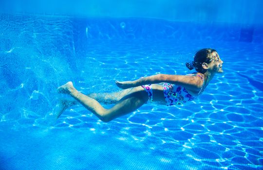 Underwater happy cute girl in swimming pool