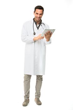 Full length portrait os a smiling male doctor with stethoscope while working with a dital tablet