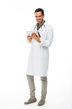 Full length portrait os a smiling male doctor with stethoscope while working with a digital tablet