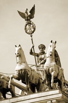 Detail of Brandenburg Gate and the Quadriga bronze statue. In german it is called Brandenburger Tor and it's one of the few monuments that survived in the defeated capital town of Berlin after second world war. King Frederick William II of Prussia commissioned the Gate and Carl Gotthard Langhans built it from 1788 to 1791.
