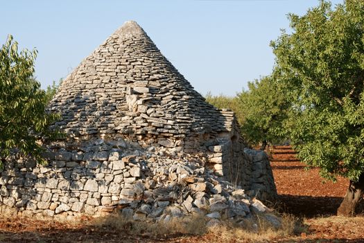 Ruins of an ancient rural trulli house in the country near Alberobello in the italian region of Apulia.