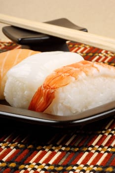 Close-up of sushi on a black tray and wooden chopsticks