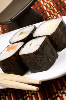 Close-up of sushi on a white tray and wooden chopsticks