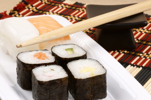 Close-up of sushi on a white tray and wooden chopsticks