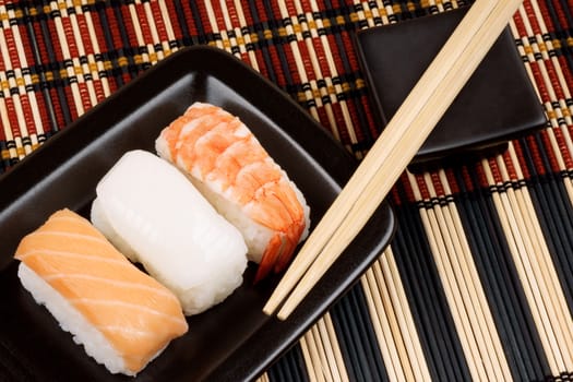 Close-up of sushi on a black tray and wooden chopsticks