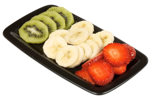 Close up of a black plate with slices of kiwi, banana and strawberry isolated on white. It could represent an organic italian flag. 