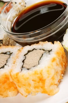 Close-up of Maki sushi rolls served on a plate with soy sauce. Selective focus.