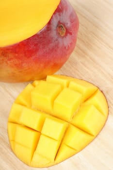 Close-up of a fresh mango over a wooden cutting board.