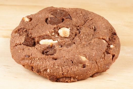 Chocolate chip and hazelnut cookie over a wooden background