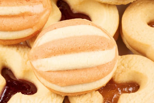 Close-up of some mixed shortcrust pastry biscuits with apricot and plum jam.