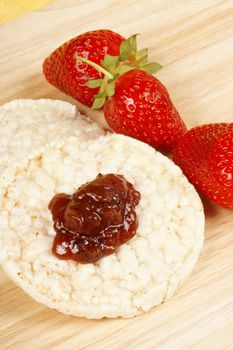 Rice cakes with jam and fresh strawberries over a wooden background. Concept for healthy eating. Selective focus.