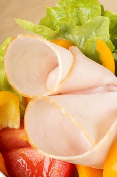 Close-up of an healthy mixed salad with roast turkey, lettuce, tomatoes and bell peppers.