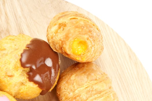 Close-up of assorted shortcrust pastry tea cakes over a wooden tray with copy space. Selective focus.