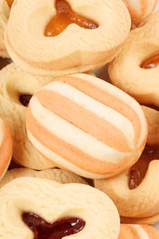 Close-up of some mixed shortcrust pastry biscuits with apricot and plum jam.