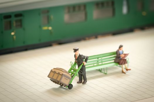miniature figure of a railway staion porter moving luggage - shallow d.o.f.