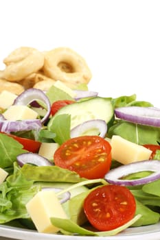 Close-up of an healthy mixed salad with cheese and some taralli in the background. With copy space. Selective focus.